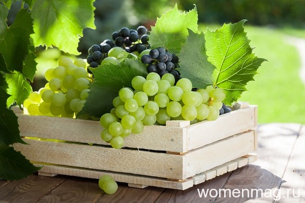 Зеленый и синий виноград в деревянном ящике